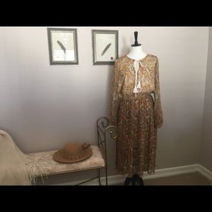 Long sleeve dress with pleated skirt bottom.